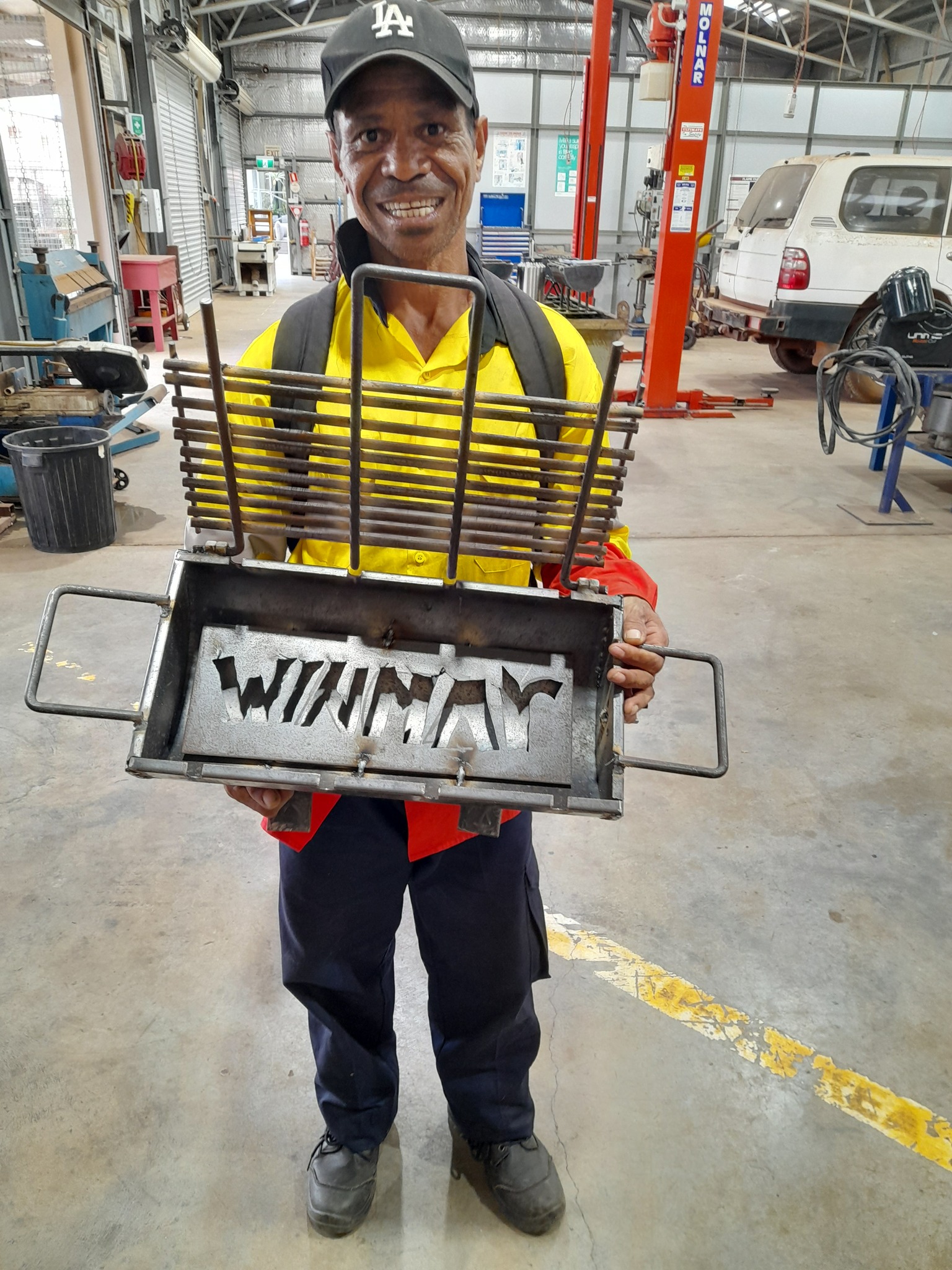 man with a BBQ he made whilst learning to weld