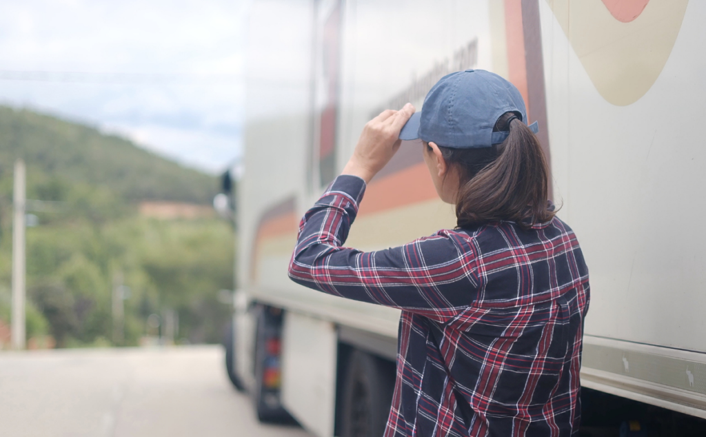 Lydia looking toward a large transport truck, preparing for a career in haul truck operations