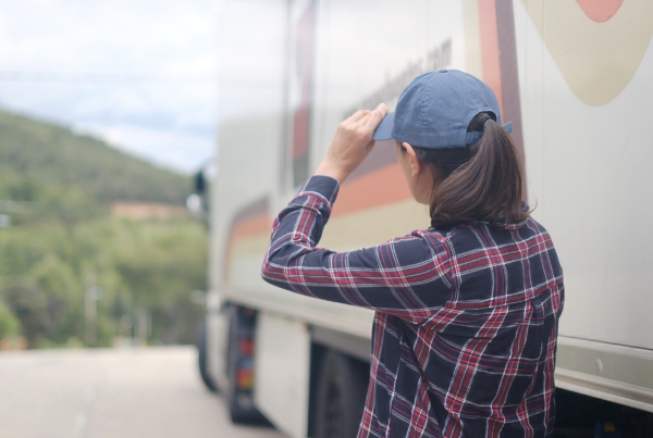 Lydia looking toward a large transport truck, preparing for a career in haul truck operations