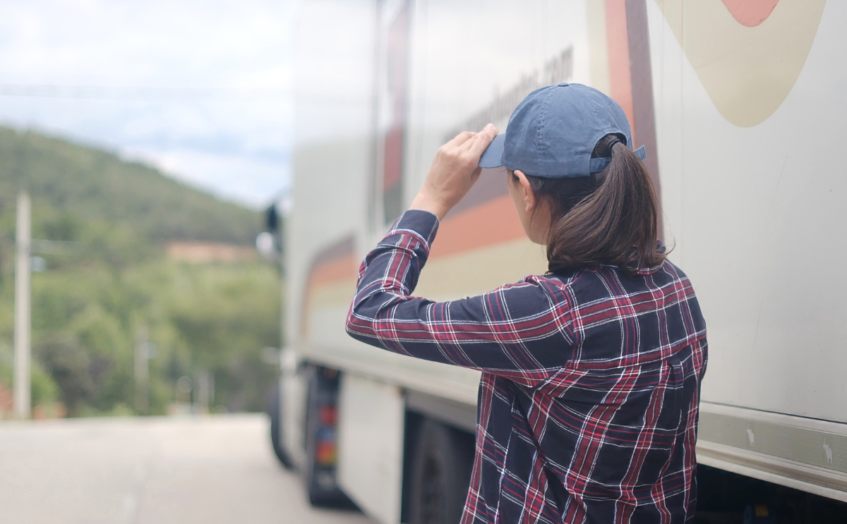Lydia looking toward a large transport truck, preparing for a career in haul truck operations