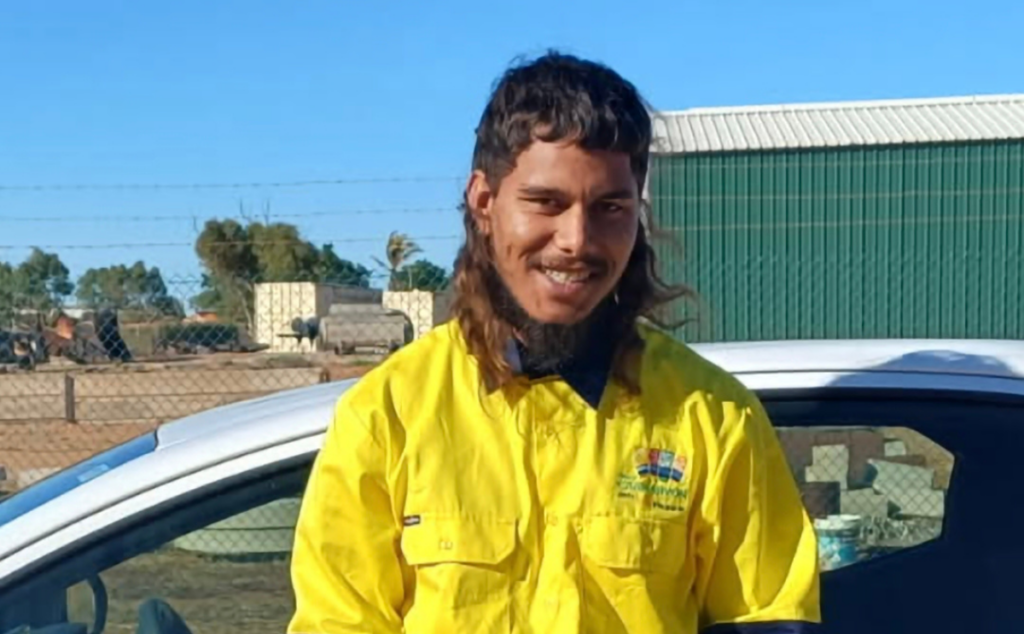 Marko smiling in his high-visibility work shirt, celebrating his journey to employment.