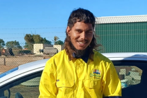 Marko smiling in his high-visibility work shirt, celebrating his journey to employment.