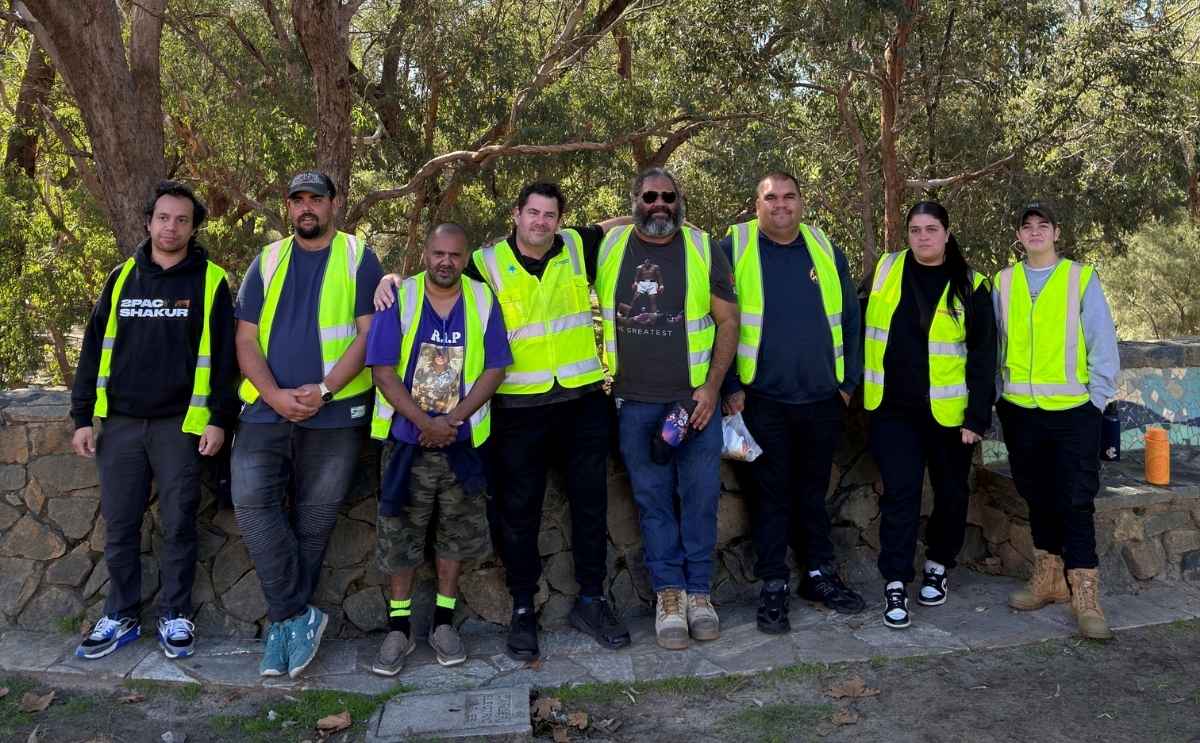 Group of Indigenous job seekers wearing high-visibility safety vests outdoors after completing traffic control training